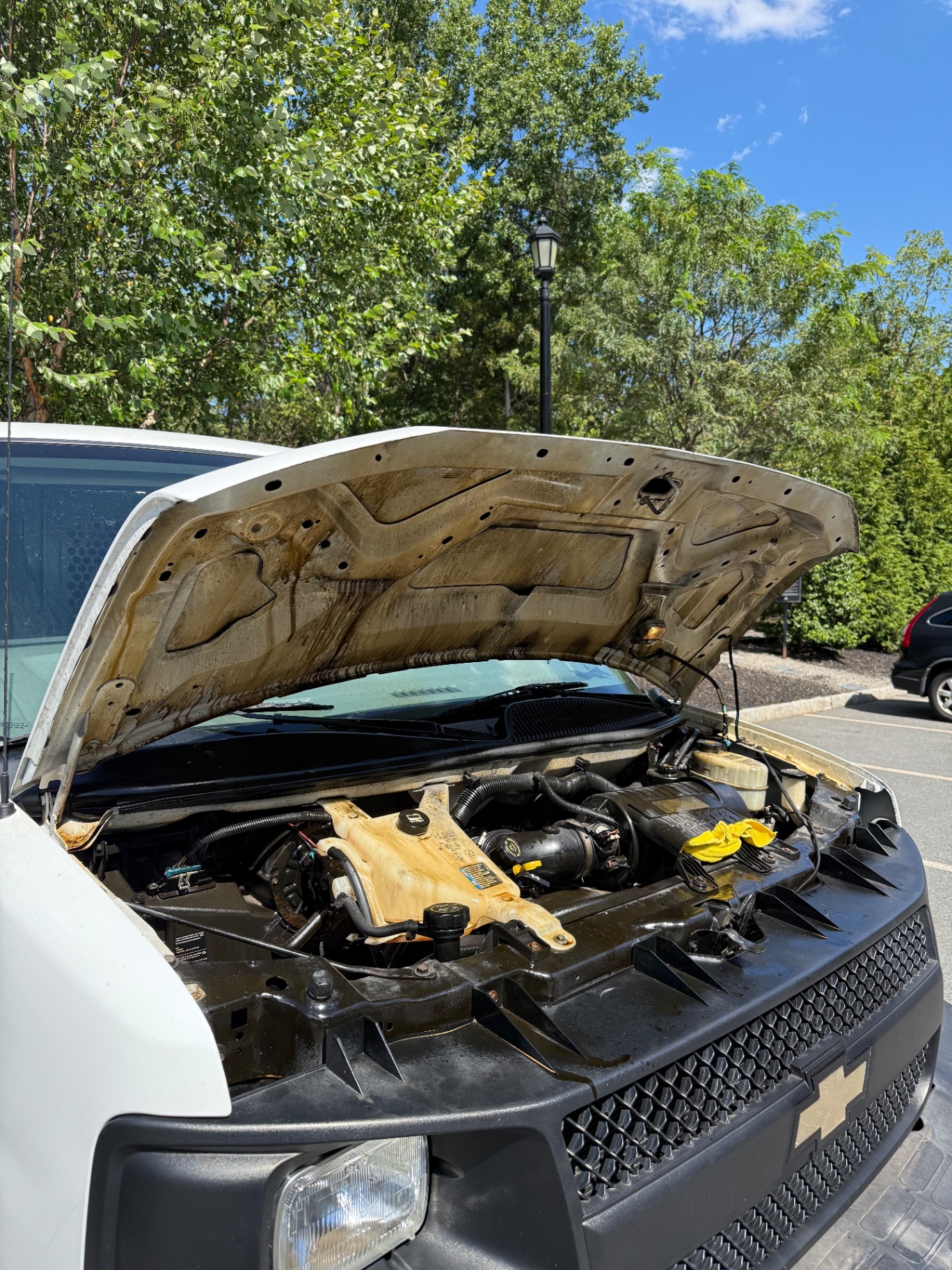 Chevy Express engine bay caked in grease and grime before cleaning