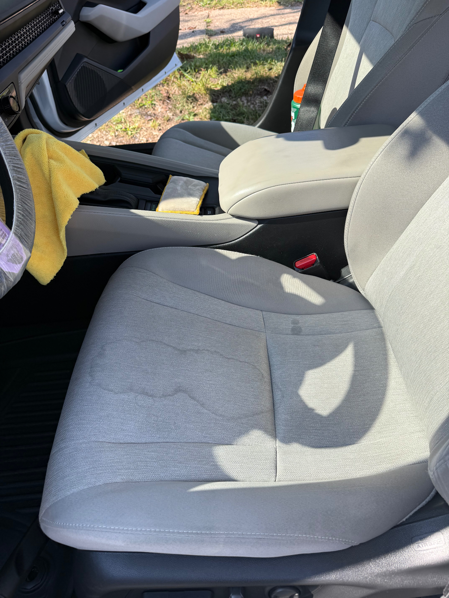 Light cloth vehicle seat with visible stains before interior extraction