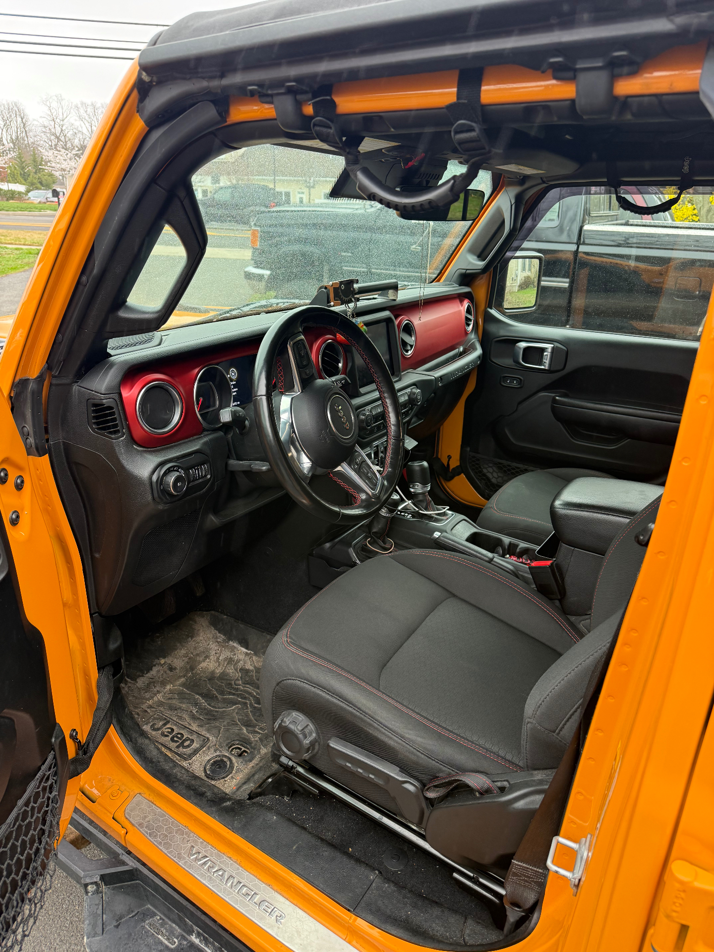 Jeep Wrangler interior with dusty dash and dirty floor mats before detailing